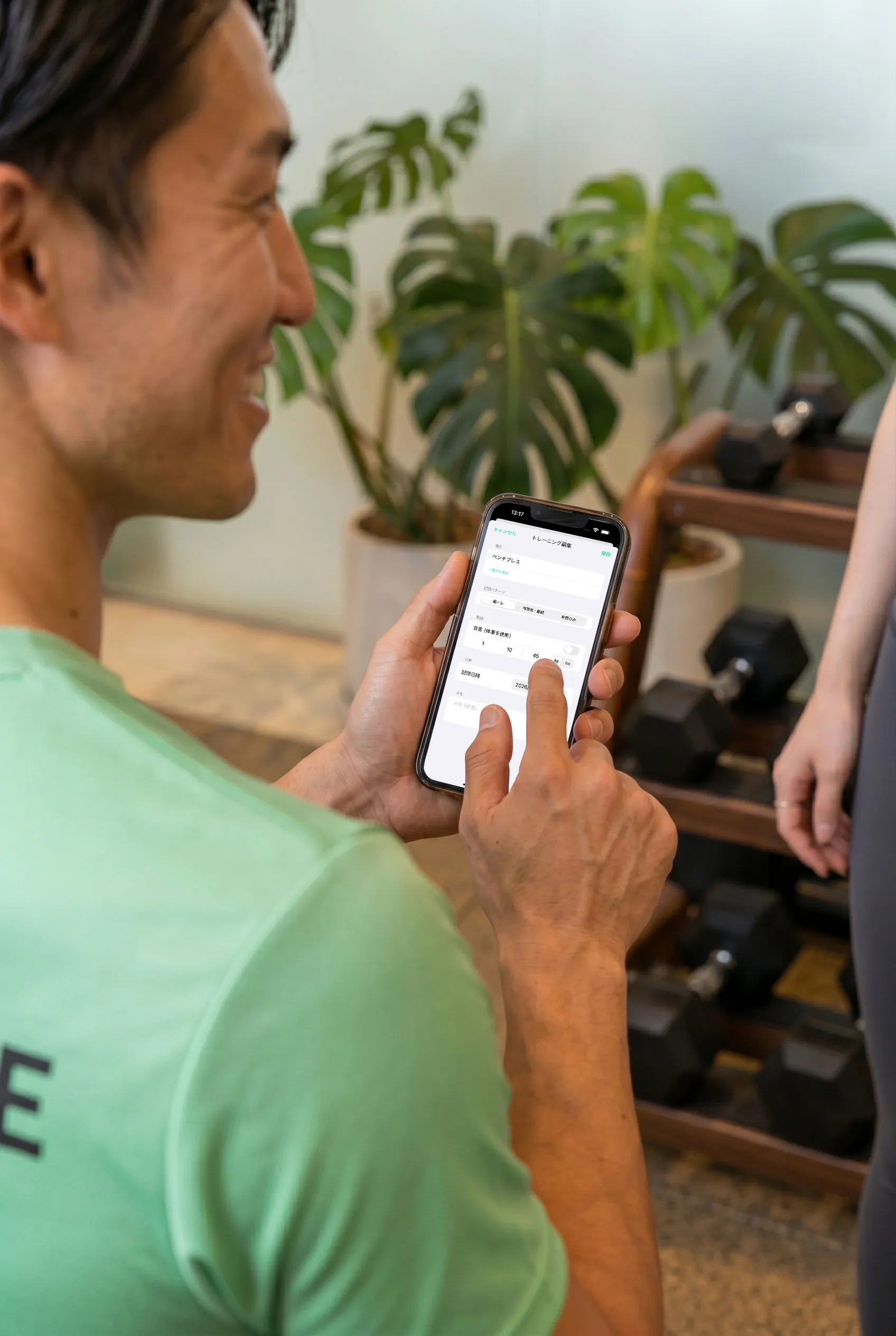 トレーナーがその場でトレーニング記録をスマホに入力している様子